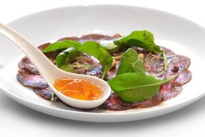 beef carpaccio with leaves and pepper jelly photo