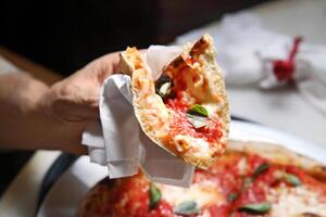 step-by-step guide on how to eat authentic Neapolitan pizza with your hands photo