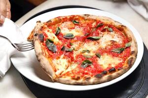 step-by-step guide on how to eat authentic Neapolitan pizza with your hands photo