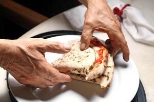 paso a paso guía en cómo a comer auténtico napolitano Pizza con tu manos foto