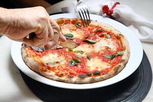 step-by-step guide on how to eat authentic Neapolitan pizza with your hands photo