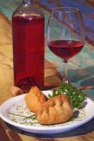 Meat empanada, a classic of Argentine cuisine accompanied by wine photo