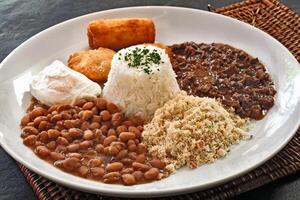 carne de vaca desmenuzar con arroz, frijoles, frito huevo, Pastelería, farofa y empanizado plátano foto