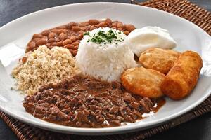 carne de vaca desmenuzar con arroz, frijoles, frito huevo, Pastelería, farofa y empanizado plátano foto