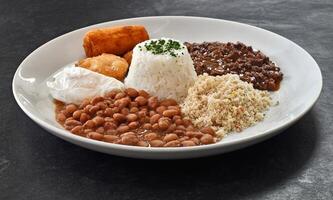 Beef mince with rice, beans, fried egg, pastry, farofa and breaded banana photo