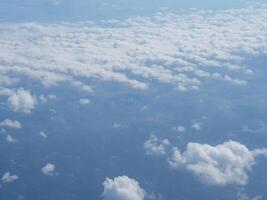 Aerial view of lands and clouds seen through the airplane window photo