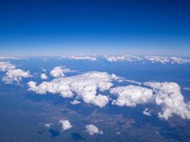 Aerial view of lands and clouds seen through the airplane window photo