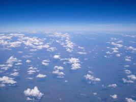 Aerial view of lands and clouds seen through airplane window photo