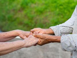 Close-up image of shaking hands between elderly women. Unity Concept photo