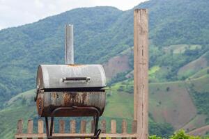 Close-up of old bbq grill stove with mountains background photo