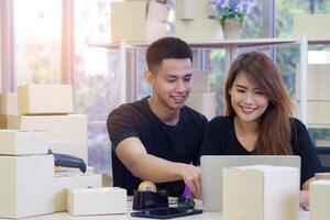 An Asian young couple is working while sitting in the office. Concept of business and e-commerce photo