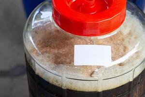 Close-up of craft beer and foam in a fermentation container. Process of making home beer from malt. Craft beer from barley and dark malt photo