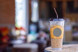 Iced coffee cup placed on a wooden table in the cafe shop. Space for text photo