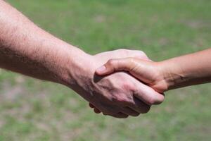 Close-up shot of man shaking hands with a woman in the garden. Concept of teamwork photo