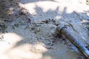 Close-up of pipe for groundwater drainage system pumps water out of the ground. Solve the drought photo