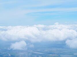 Aerial view of lands and clouds seen through airplane window photo