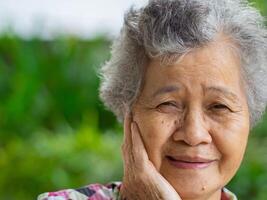 Close-up face of a beautiful smiling senior woman and looking at the camera. Concept of aged people and healthcare photo