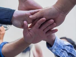 Many people hands in a circle together. Low angle of view. Concept of teamwork and unity photo