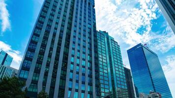 A timelapse of cloud reflecting the building in the business town wide shot tilt video