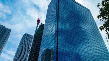 A timelapse of cloud reflecting the building in the business town wide shot panning video