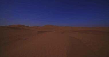 A panoramic sand dune of sahara desert at Mhamid el Ghizlane in Morocco wide shot tilt up video