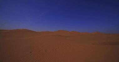 A panoramic sand dune of sahara desert at Mhamid el Ghizlane in Morocco wide shot panning video