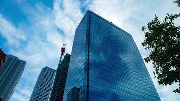 A timelapse of cloud reflecting the building in the business town wide shot tilt video