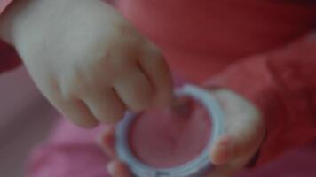 Cheerful confident caucasian toddler using eyeshadows. Little girl painted her lips and eyelids just for fun. Close up of little hands and eyeshadows video