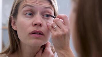 Matin routines. Jeune magnifique femme fabrication faire en haut près miroir video