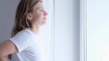 ochtend- routines. vrouw staand door slaapkamer venster en opening gordijnen video