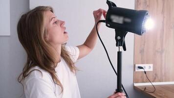 young woman working on content making using and controlling light strobe video