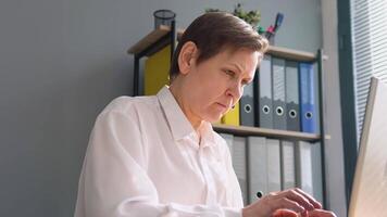 Senior Frau funktioniert hinter ein Laptop. Konzept von Fernbedienung Arbeit video