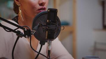 Close up of woman talking on microphone during streaming. On-air online production internet broadcast show host streaming live content, recording digital social media communication video