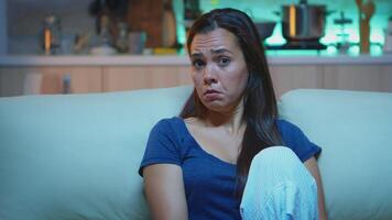 Focused young woman paying attention to film with a shocked concentrated and amazed facial expression. Emotionally awestruck and wide-eyed lady reacting to an impressive and astonishing moment on tv video