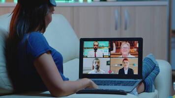 vrouw streaming online webinar opleiding Bij nacht van huis. afgelegen arbeider hebben online ontmoeting, conferentie overleg plegen met collega's gebruik makend van telefoontje en webcam babbelen werken in voorkant van laptop. video