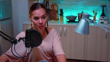 Woman vlogger recording podcast in home studio iluminated with neon light. Creative online show On-air production internet broadcast host streaming live content, recording digital social media communication video