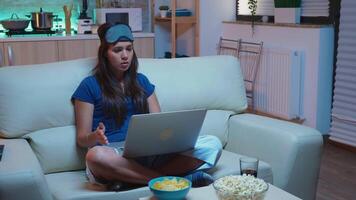 Woman with insomnia talking with mother on webcam late at night. Exhausted person in pijamas with sleep mask having call on laptop computer speaking with parents using internet technology. video