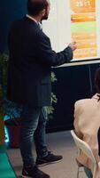 Sales manager creates a presentation to pitch in a new strategy for development, using interactive board to make his staff members understand the objectives. Business planning meeting. Camera B. video