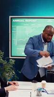 Project manager meeting with his executive team in a boardroom office, looking into updates on regulatory changes that can affect their tasks. Leader sharing gathered analysis on papers. Camera B. video