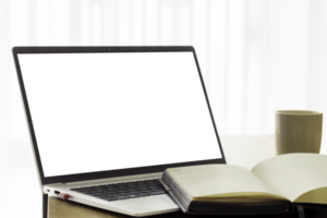 laptop with blank screen on wooden table, paper notebook and white coffee cup nearby. blurred background png