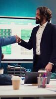 Business partners celebrate the beginning of a new project between their companies, shaking hands in a meeting. Leaders forging an agreement to develop the corporation and collect resources. Camera B. video