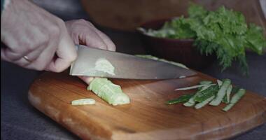 huis keuken. salade van vers voorjaar groenten. snijden komkommers Aan een snijdend bord video