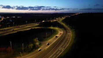 antenn tid upphöra natt antal fot av upplyst brittiskt motorvägar och trafik på m1 korsning 9 på bara efter solnedgång. renbourn, England förenad rike. april 7:e, 2024 video