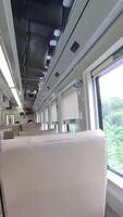 Subang, Indonesia on March 3 2024. Interior of the Economy class North Kutojaya Passenger Train. Brown benches, large side windows so you can see the view. The train goes to Kutoarjo. video