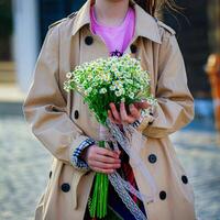 mujer sostiene ramo de flores de flores en zanja Saco foto