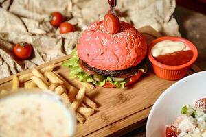 hamburguesa con queso con en forma de corazon bollo y lado de papas fritas foto