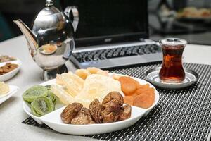 Plate of Assorted Fruit and Nuts With a Cup of Tea photo