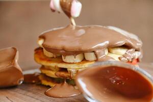 Stack of Pancakes Covered in Chocolate Frosting photo