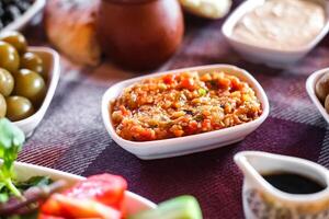 mesa adornado con bochas de comida y Olivos. foto