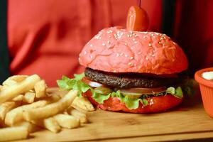 jugoso hamburguesa y crujiente francés papas fritas en un mesa foto